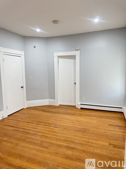 A room with wooden floors and two white doors.