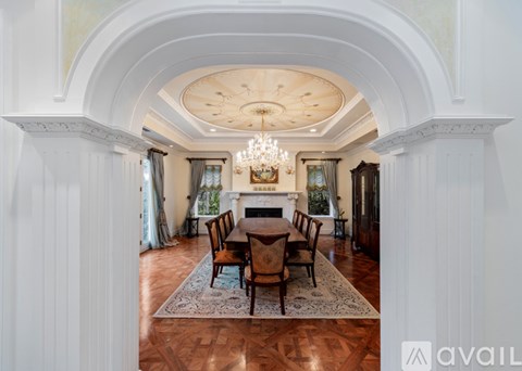 A dining room with a wooden table and chairs.