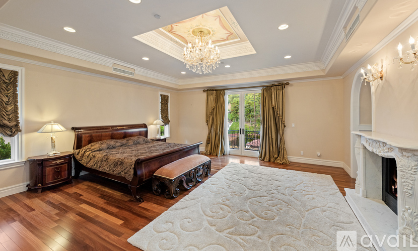 A bedroom with a large bed and a fireplace.