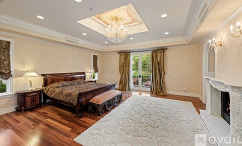 A bedroom with a large bed and a fireplace.