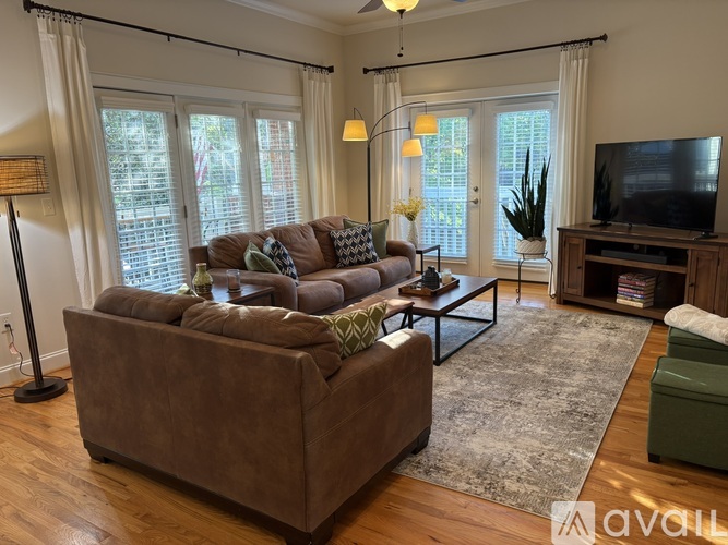 A living room with a brown couch and a television.