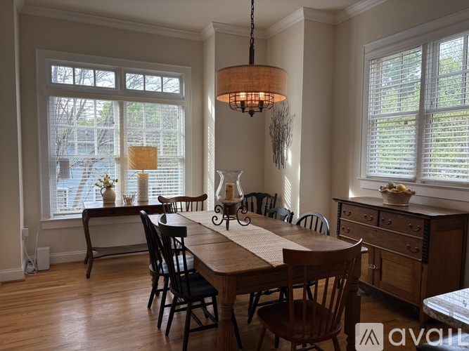 A dining room with a wooden table and chairs.