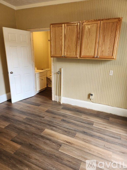 A room with wooden floors and cabinets.