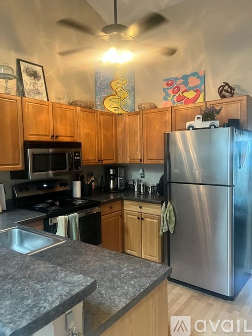 A kitchen with wooden cabinets and a stainless steel refrigerator.