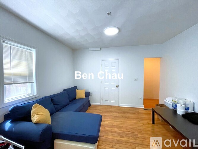 A living room with a blue couch and a white wall.