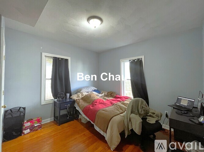A bedroom with a bed, desk, and window.