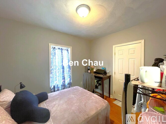A bedroom with a bed, desk, and chair.