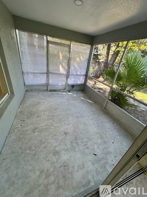 A room with a view of trees through the window.
