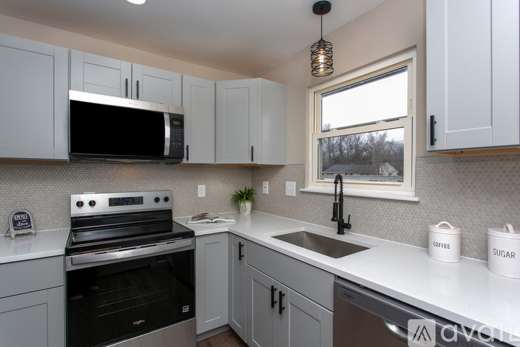 A kitchen with white cabinets and a black stove top oven.