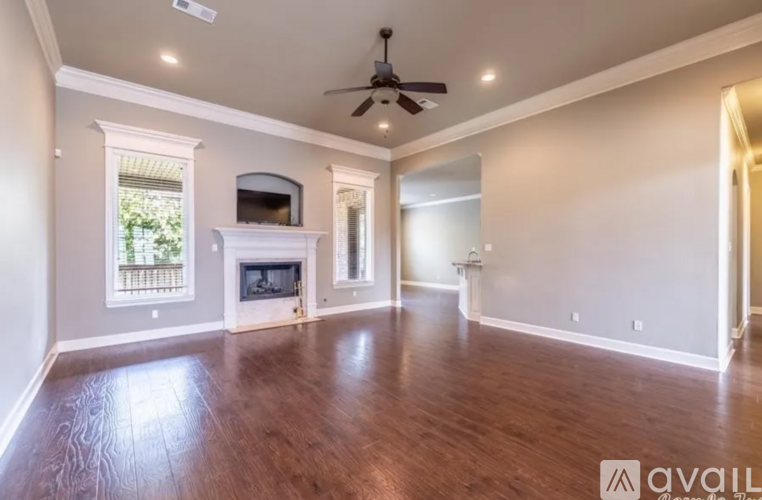 A spacious room with a fireplace and a television.