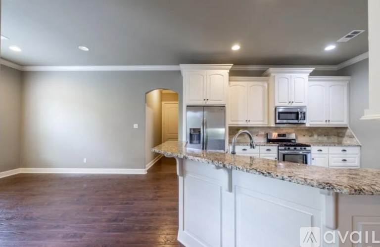 A kitchen with white cabinets and a granite countertop.