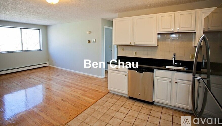A kitchen with white cabinets and a black countertop.
