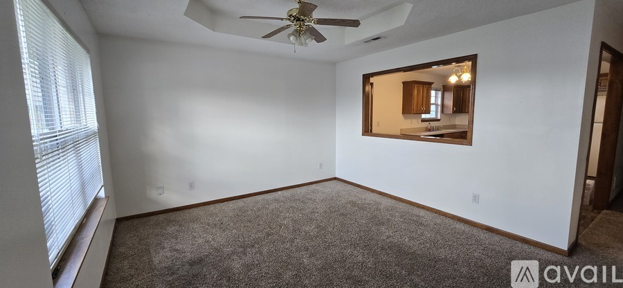 A room with a ceiling fan and a large mirror on the wall.