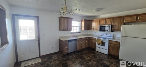 A kitchen with a white refrigerator and a white stove top oven.