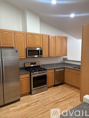 A kitchen with wooden cabinets and stainless steel appliances.
