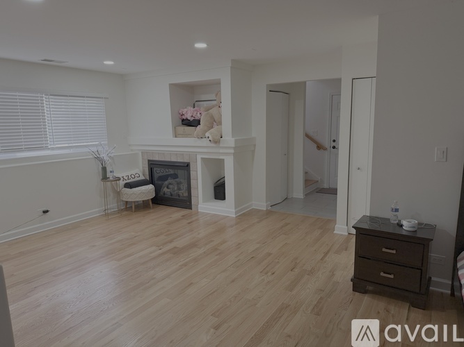 A living room with a fireplace and a teddy bear on the mantle.