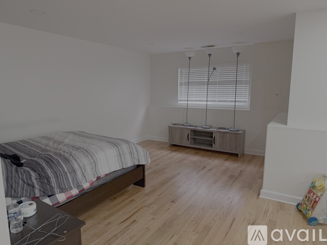 A bedroom with a bed, nightstand, and a wooden cabinet.