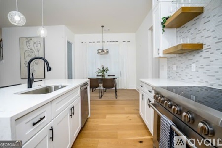 A kitchen with white cabinets and a black stove top oven.