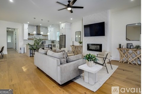 A spacious living room with a grey sofa and a white coffee table.
