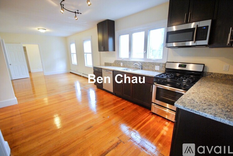 A kitchen with a bench seating area and a microwave above the stove.