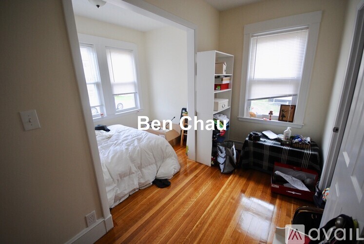 A bedroom with a bed, a desk, and a bookshelf.