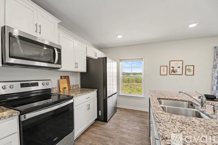 A kitchen with a black oven and microwave above a granite countertop.