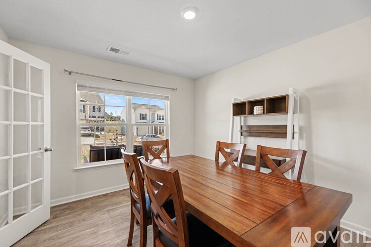 A dining room with a wooden table and chairs.