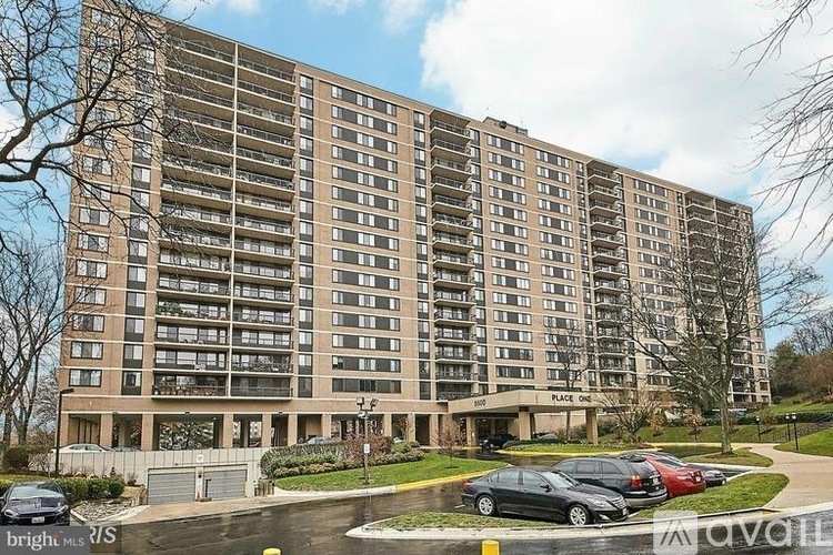 A large apartment building with a parking lot in front.