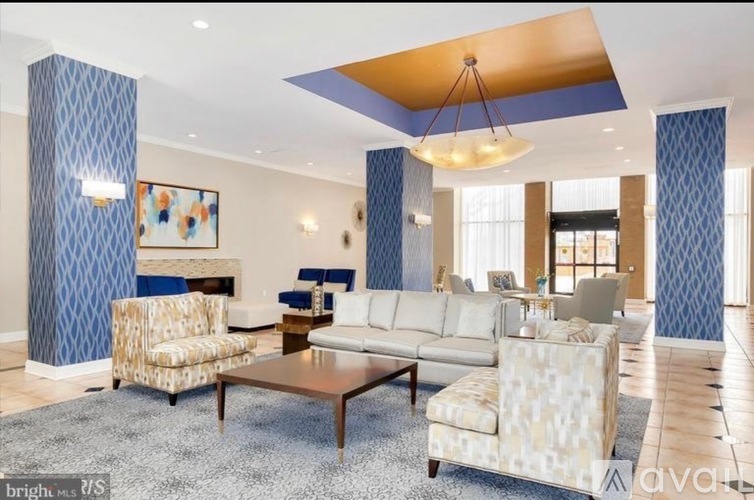 A living room with a patterned blue wallpaper and a patterned sofa.