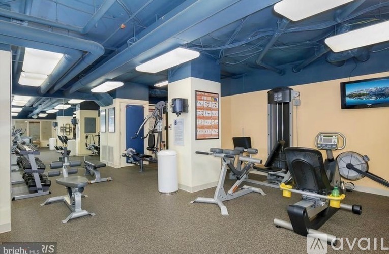 A gym with a variety of exercise equipment including treadmills, stationary bikes, and weight machines.