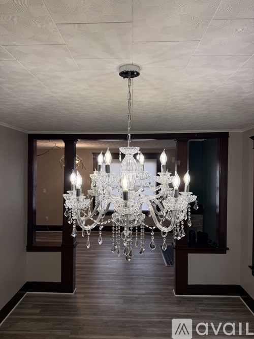 A large chandelier hangs from the ceiling in a spacious room.
