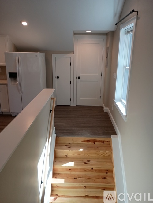 A wooden staircase leads to a white door.