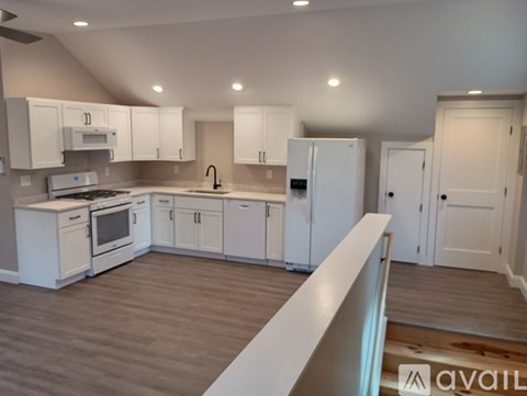 A kitchen with white cabinets and appliances is available for rent.
