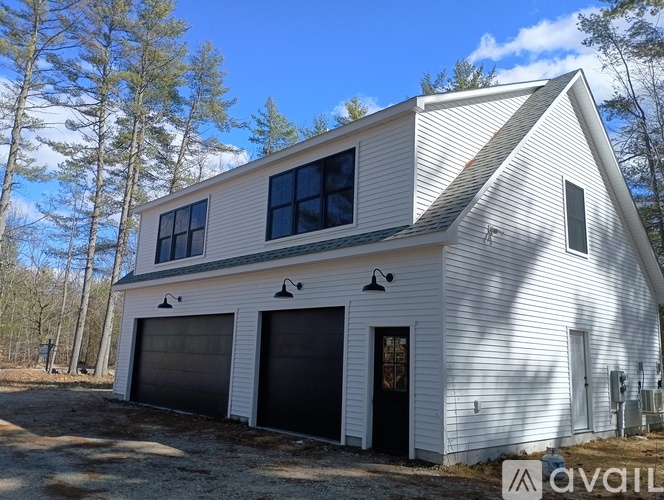 A two-car garage with a white exterior and a black door is available for rent.