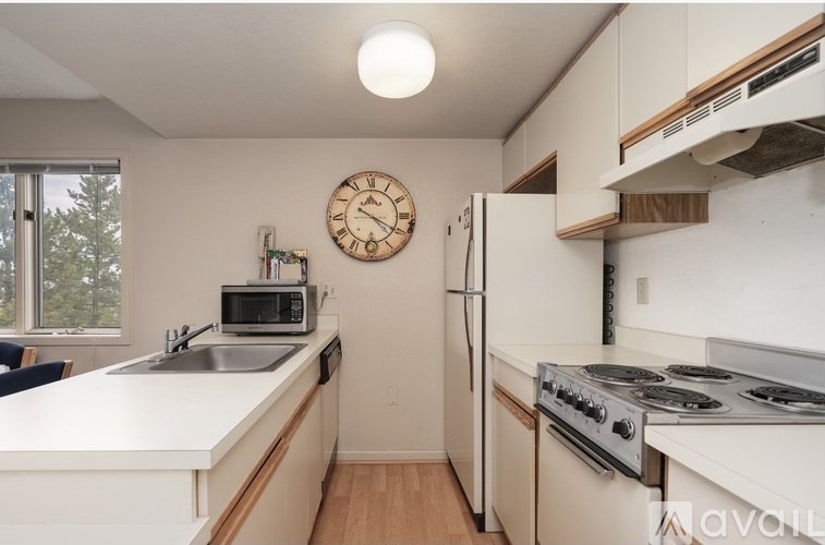 A kitchen with a white countertop and a clock on the wall.