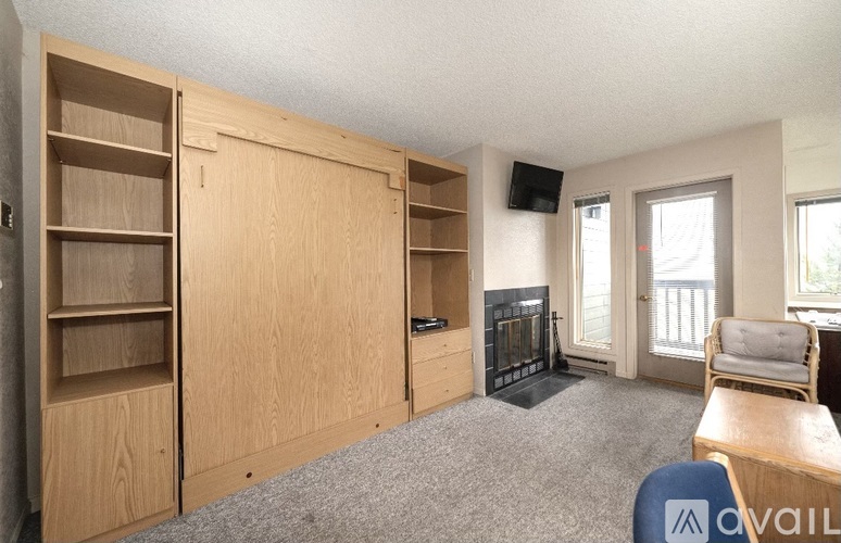 A living room with a fireplace and a TV mounted on the wall.