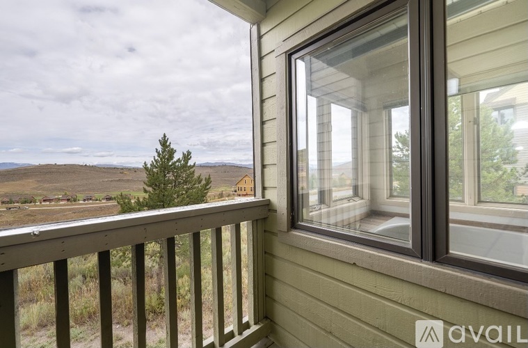 A balcony with a view of a house and trees.