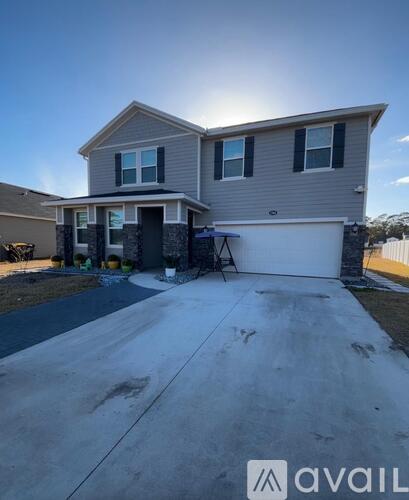 A two-story house with a garage is available for sale.