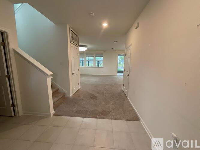 A spacious hallway with a carpeted floor and white walls.