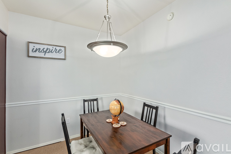 A dining room with a wooden table and chairs.