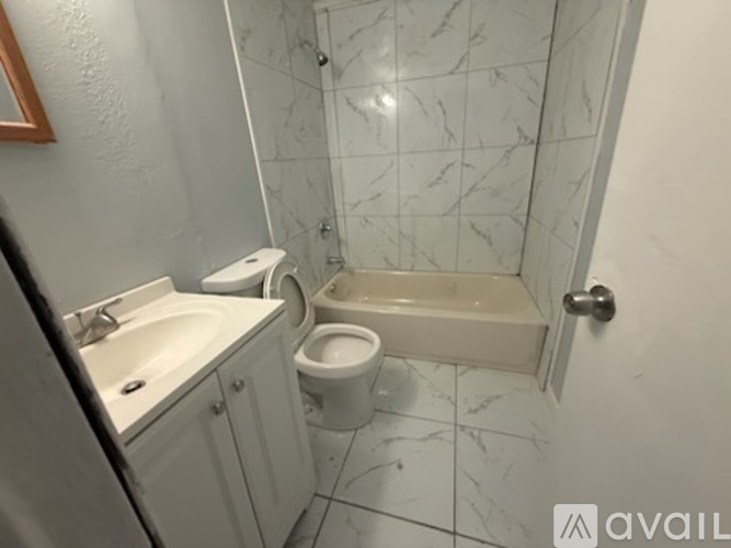 A bathroom with a toilet, sink, and bathtub.