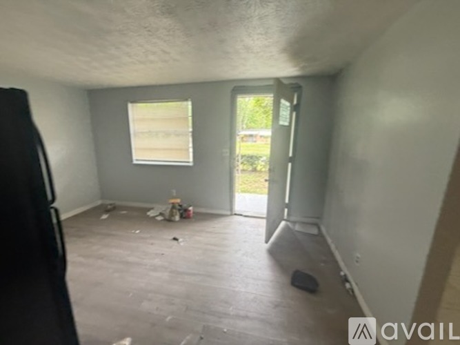 A room with a window and a door leading outside.