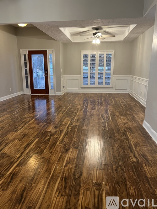 A room with wooden flooring and a ceiling fan.