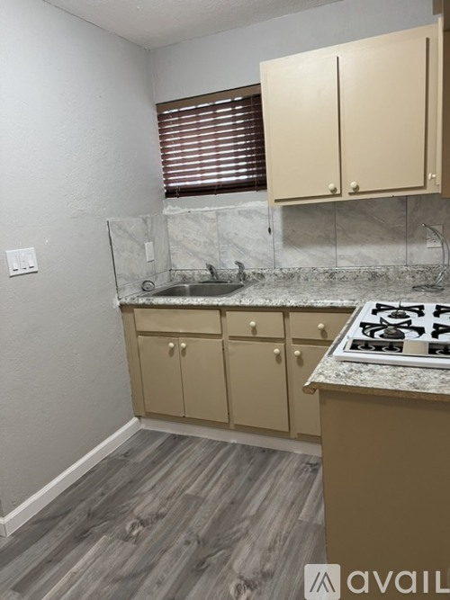 A kitchen with a marble countertop and wooden cabinets.