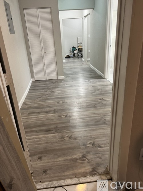 A hallway with wooden floors and white doors.