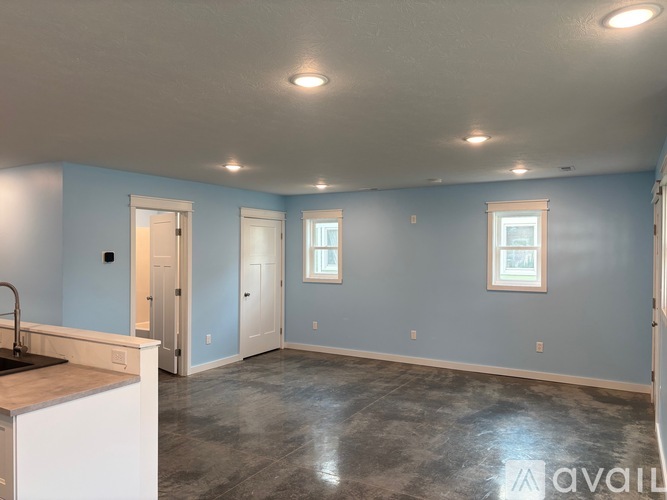 A spacious room with a kitchen area and a sink.
