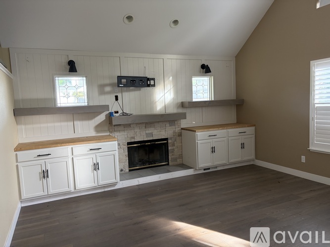 A living room with a fireplace and built-in cabinets.