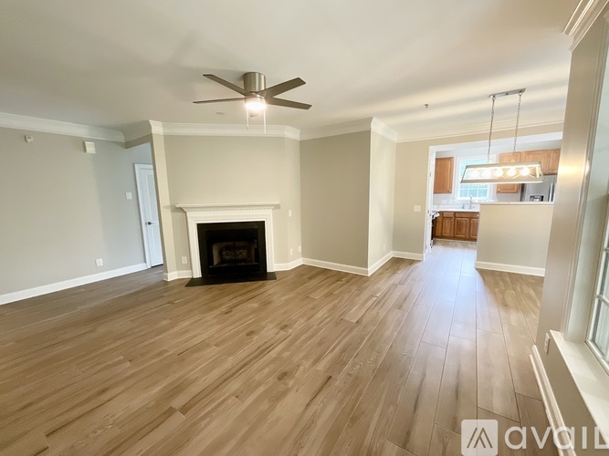 A spacious room with a fireplace and a ceiling fan.