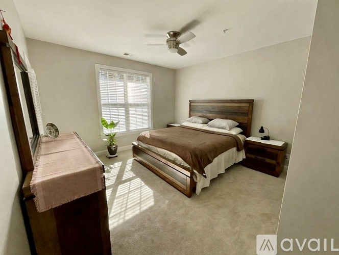 A bedroom with a bed, dresser, and window.