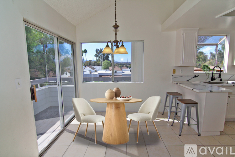 A kitchen with a table and chairs in front of a window.